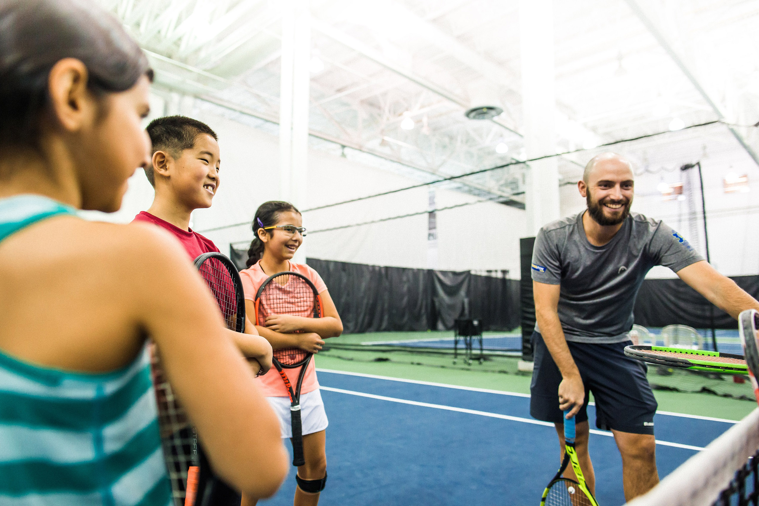 kids learning tennis with coach