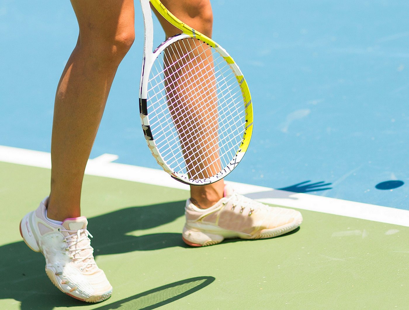woman with tennis shoes and racquet