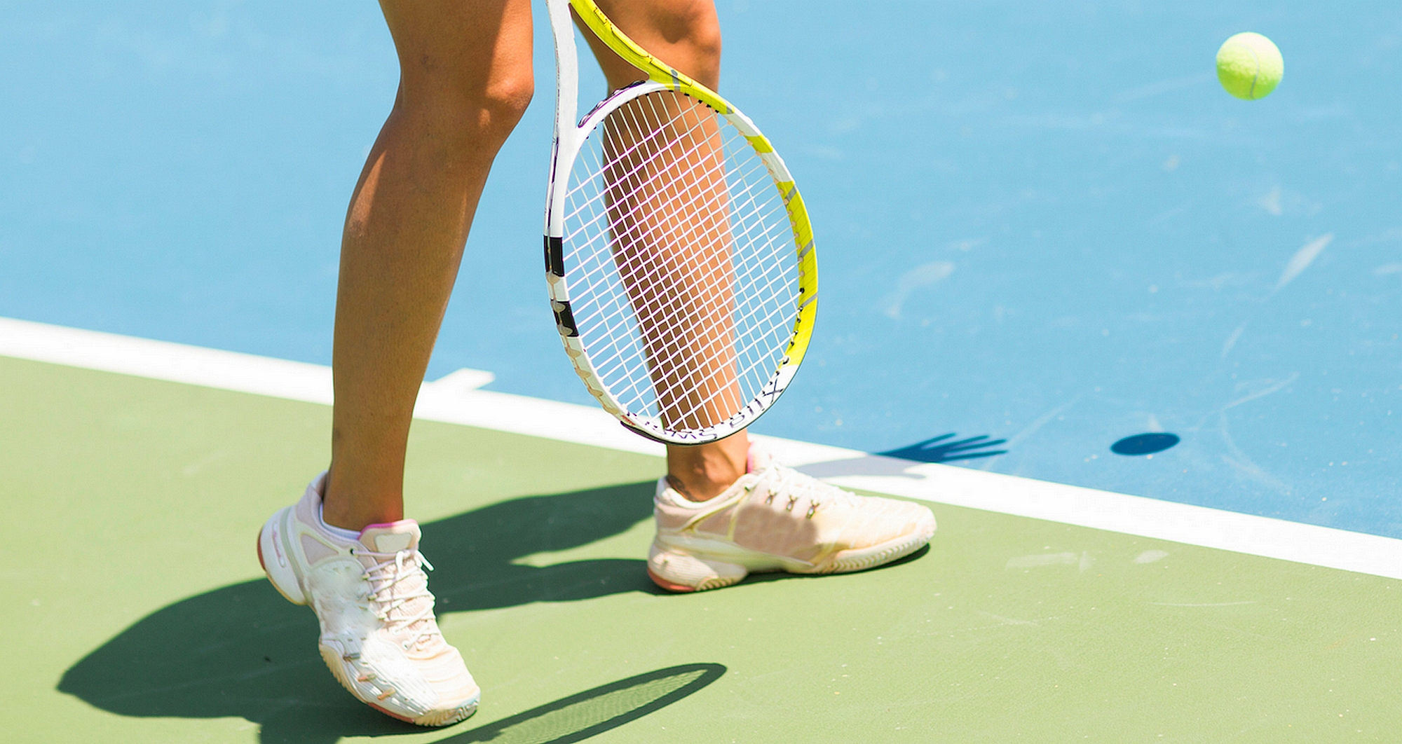 woman with tennis shoes and racquet