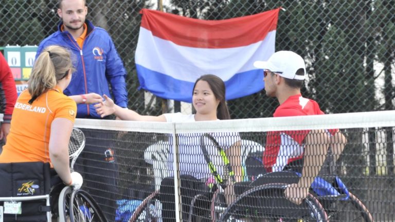 Wheelchair tennis players shaking hands on court