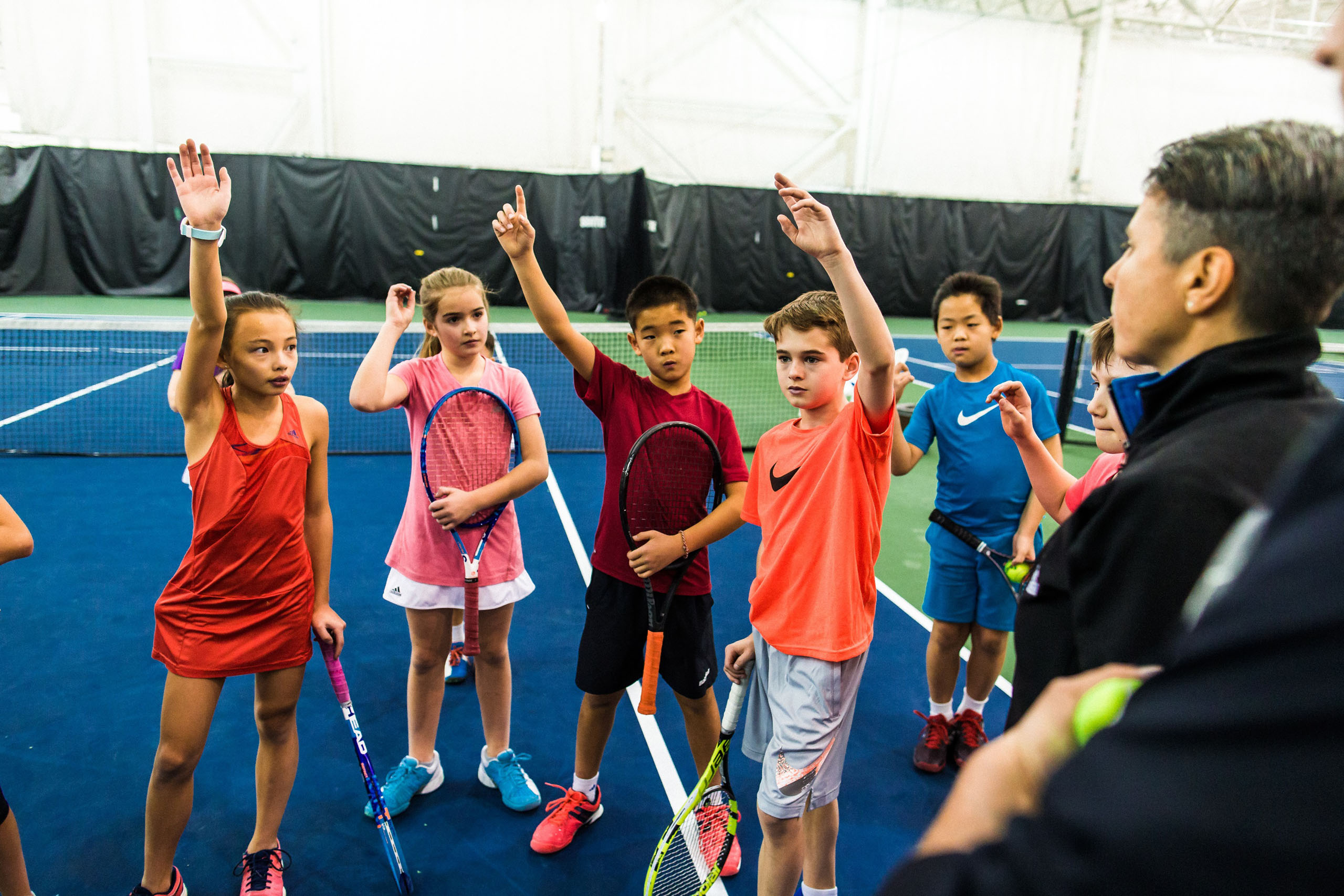 Children and trainer on tennis court