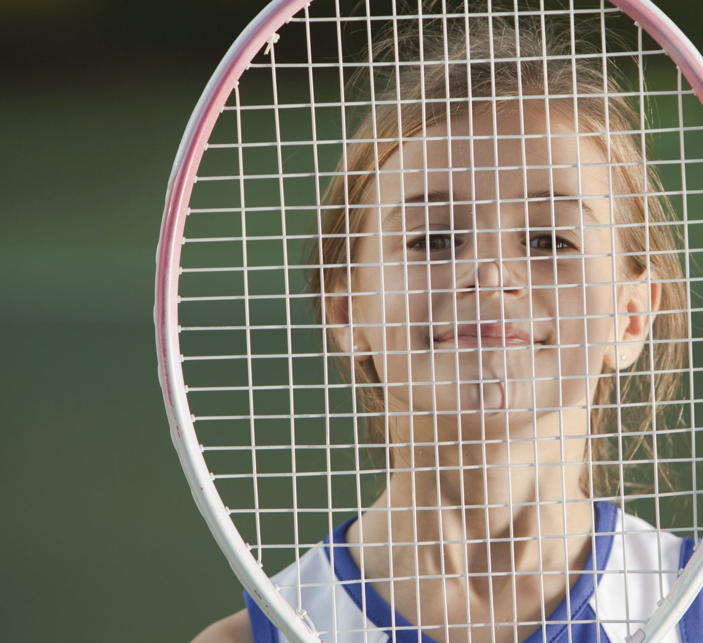 Young girl behind tennis racquet