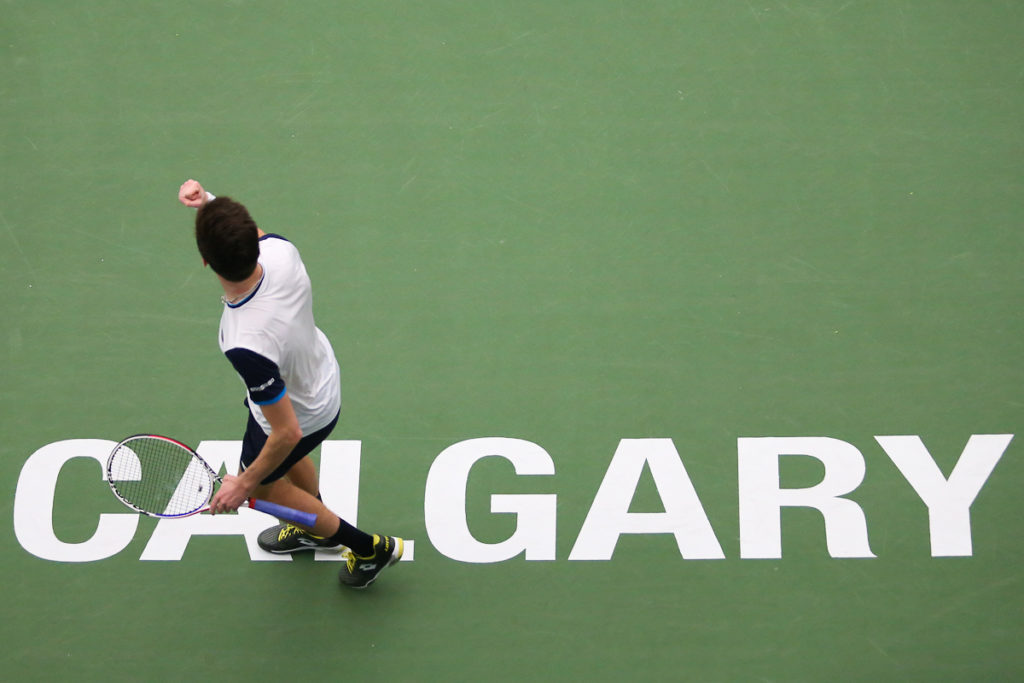 A player lifts his fist as he walks over the Calgary sign on court