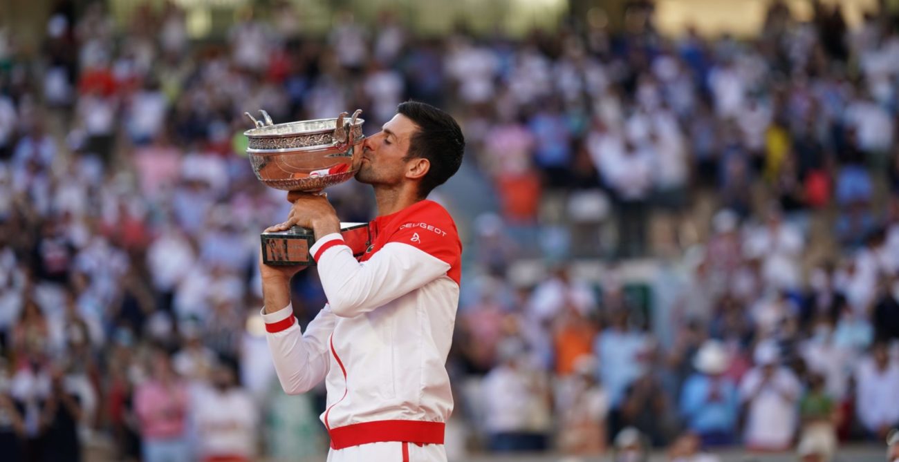 Djokovic kisses the ROland Garros trophy in front of a crowd