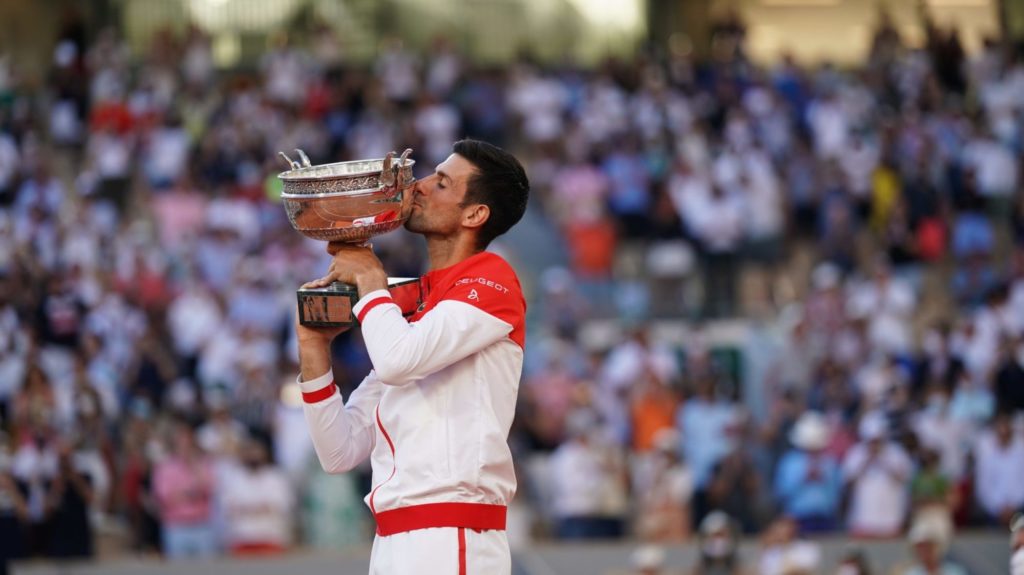 Djokovic  kisses the ROland Garros trophy in front of a crowd
