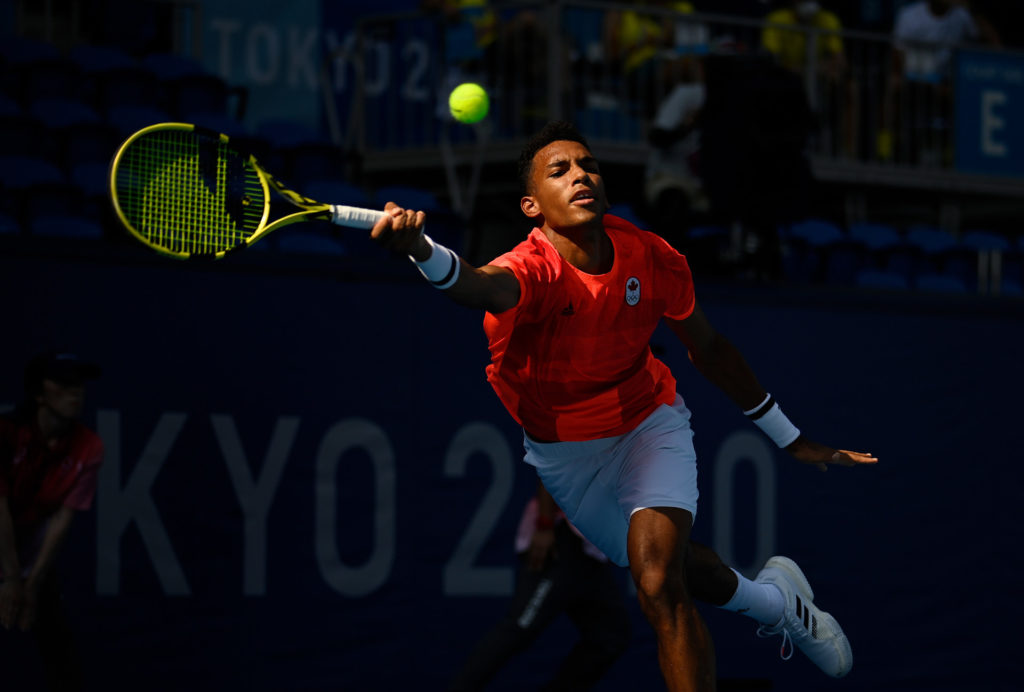 Félix AugerAliassime stretches to hit a forehand in the Tokyo Olympics