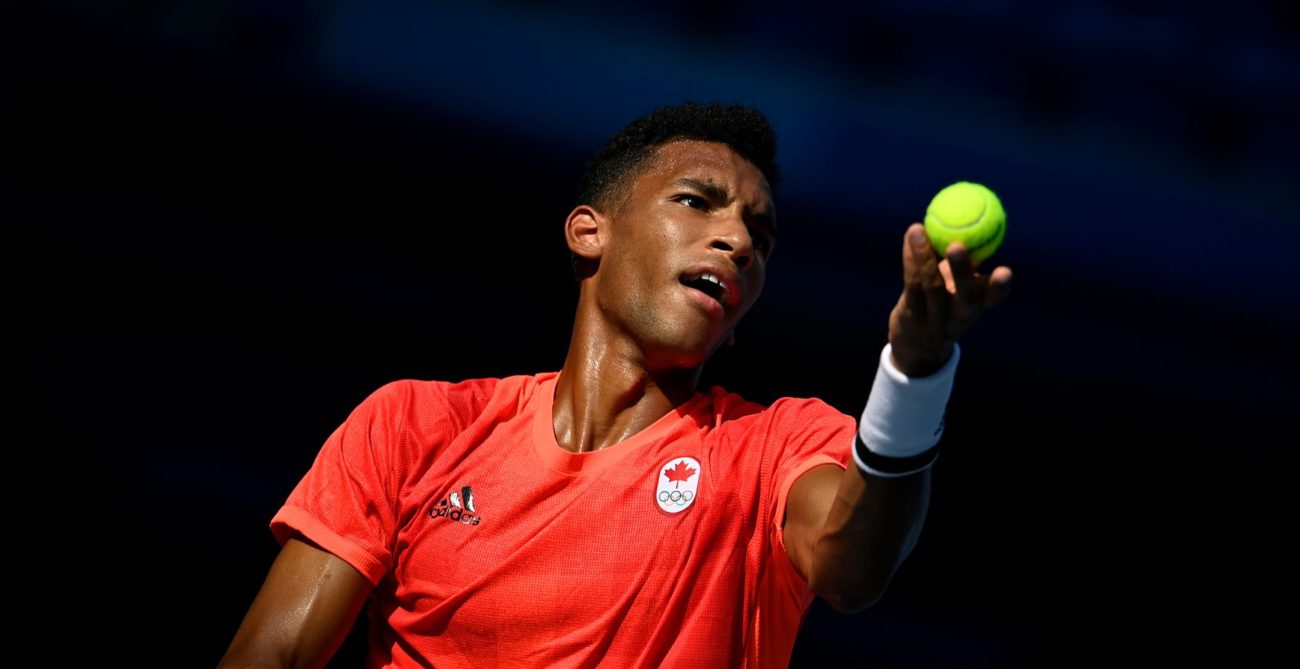 Félix Auger-Aliassime tosses the ball to serve.