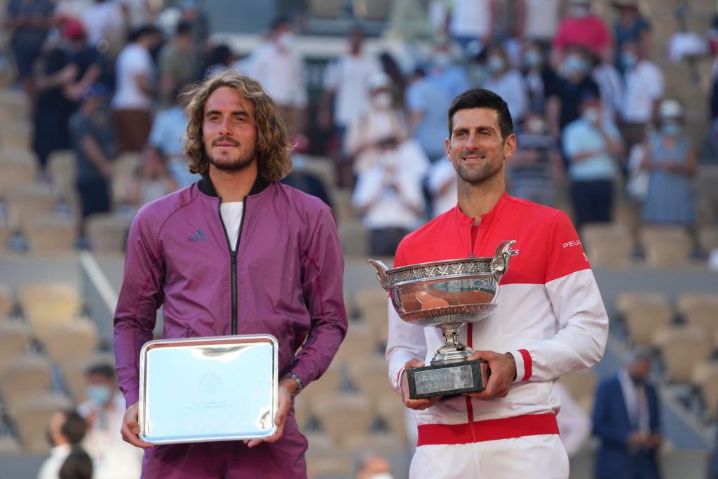 Novak Djokovic and Stefanos Tsitsipas stand side by side with the Roland Garros winner and runner-up trophies