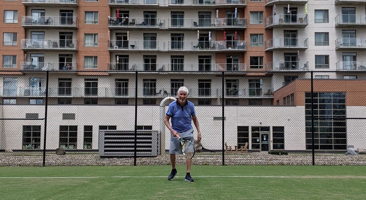 Senior man playing tennis and smiling