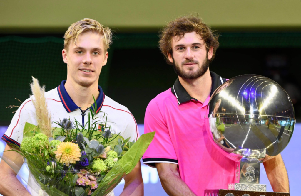 Denis Shapovalov holds flowers standing next to Tommy Paul holding the trophy.