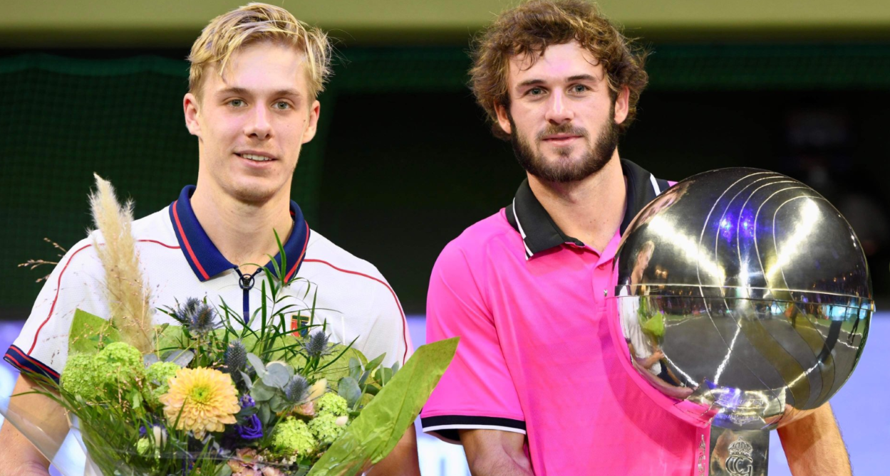 Denis Shapovalov holds flowers standing next to Tommy Paul holding the trophy.