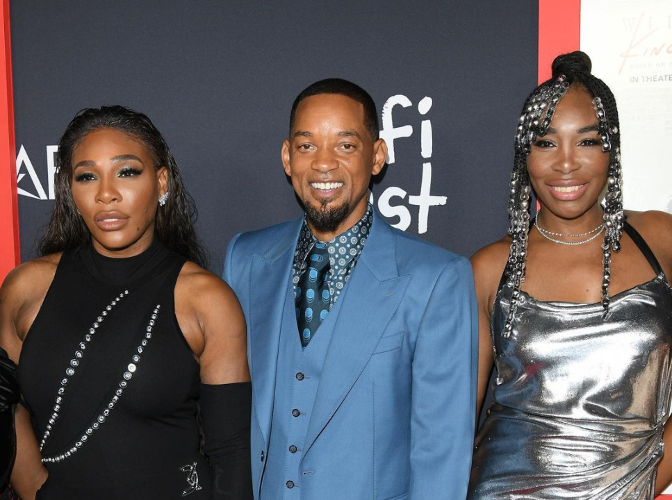 Serena Williams, Will Smith, and Venus Williams stand next to each other on the red carpet.