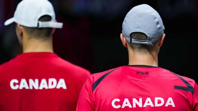 Two players wearing a red shirt with Canada written on, seen from their back