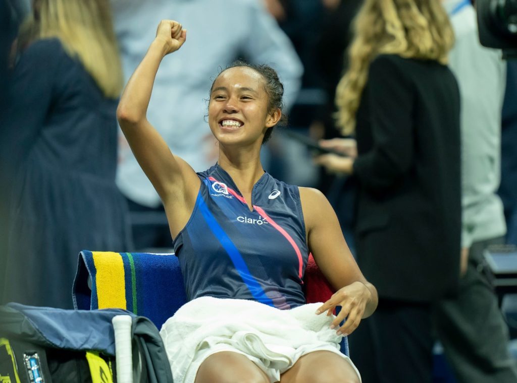 Fernandez lifts her fist and smiles while sitting on her player cair at the US Open