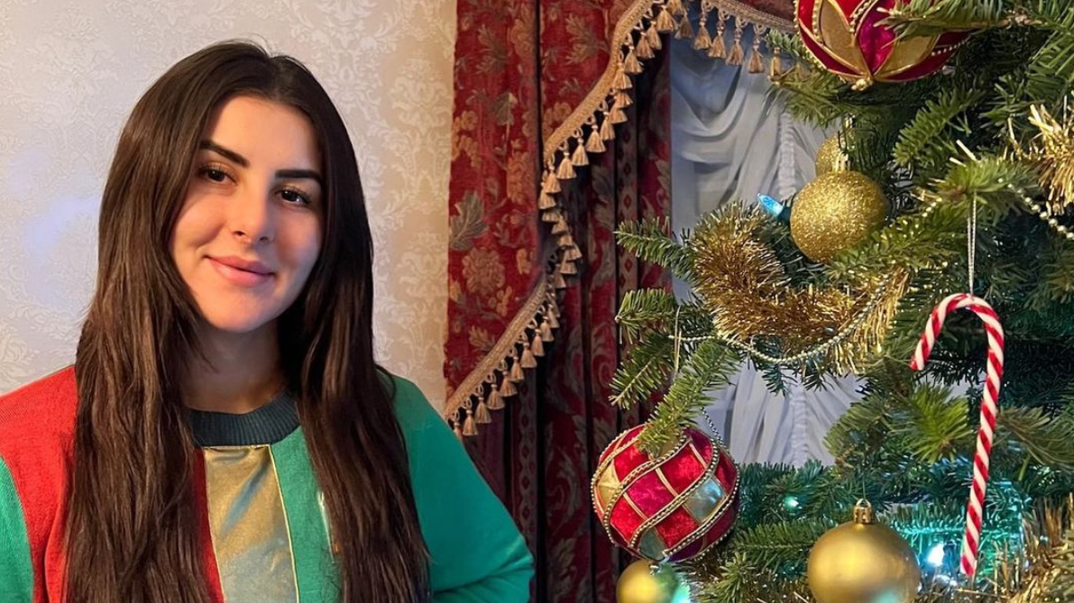 Bianca Andreescu stands next to a Christmas Tree.