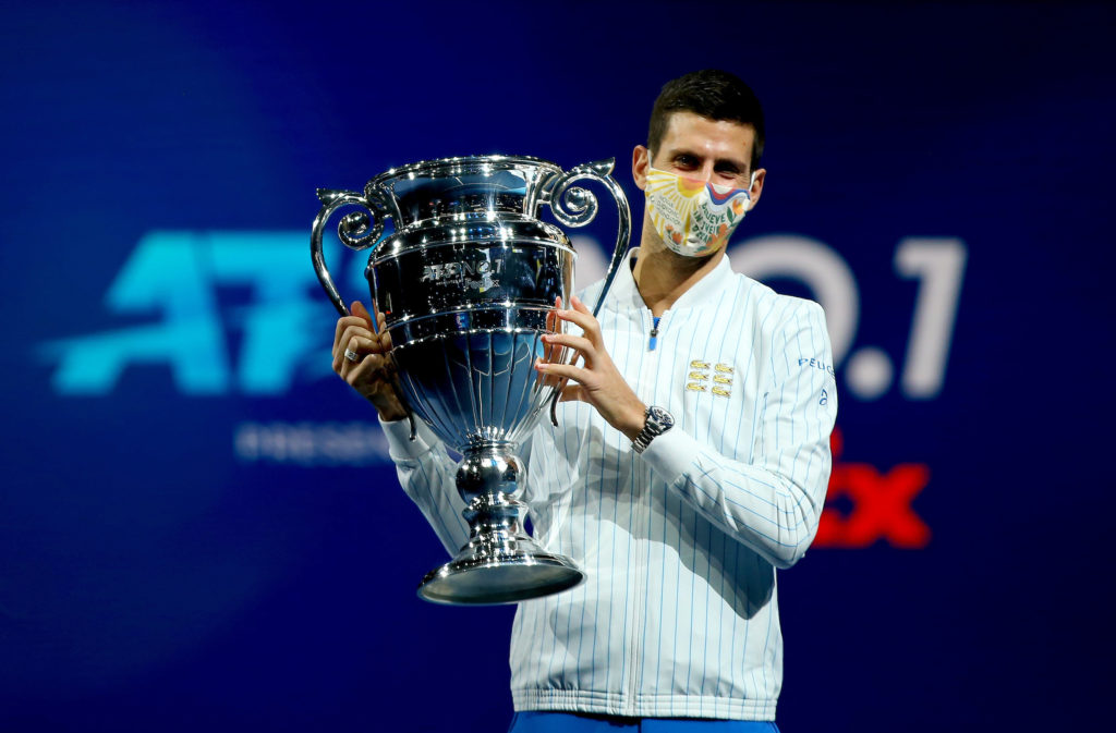 Novak Djokovic holds the ATP No. 1 trophy and wears a mask