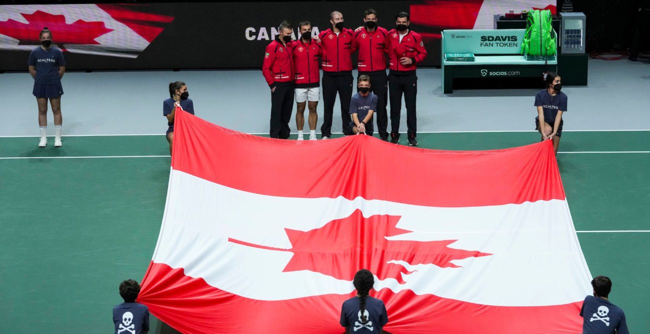 Team Canada at davis cup in front of a giant Canada flag held by ball kids before a tie starts