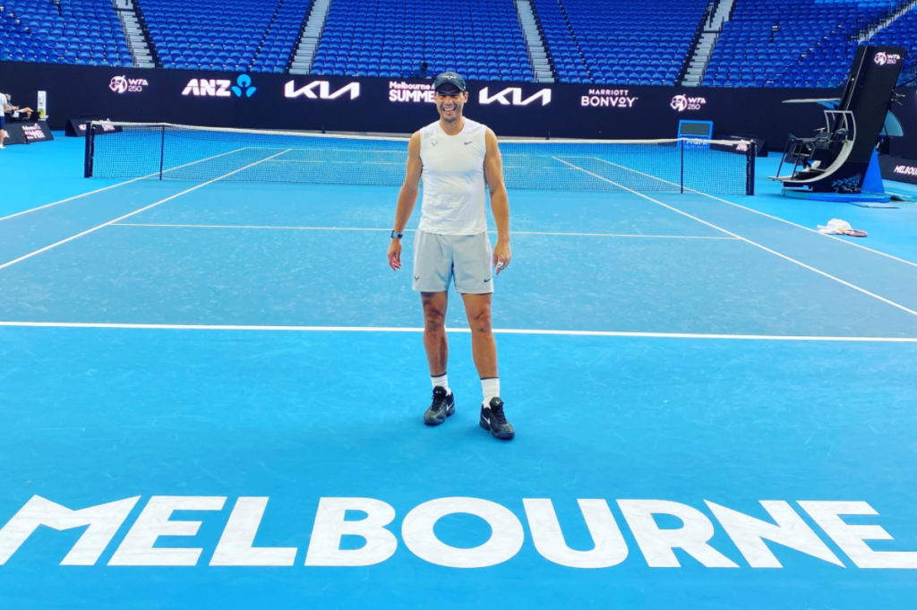 Rafael Nadal stands on the court in front of the "Melbourne" sign