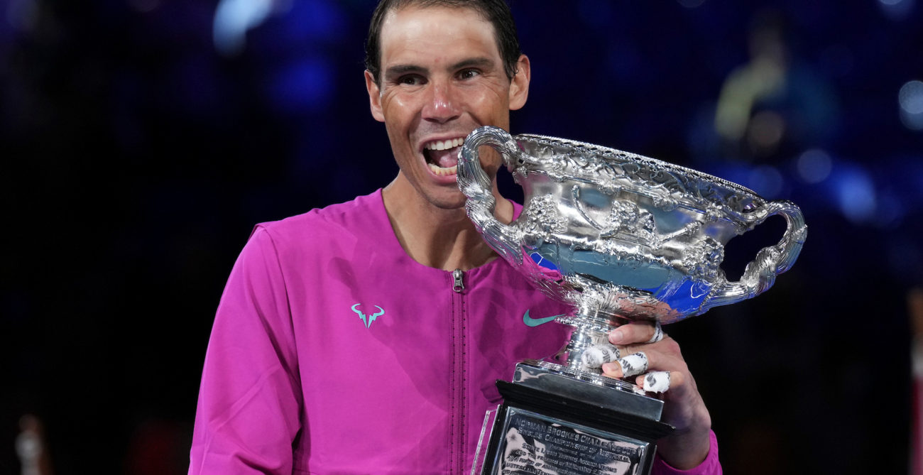 Rafael Nadal bites the trophy.
