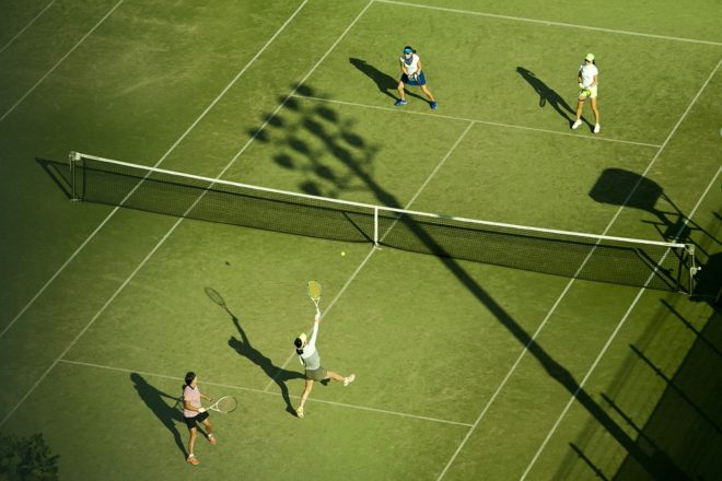 Amateurs playing tennis in doubles, aerial view