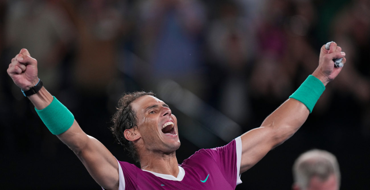 Rafael Nadal raises his arms in the air.