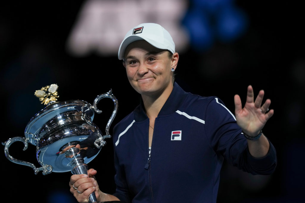 Ashleigh Barty holds the Australian Open trophy and waves