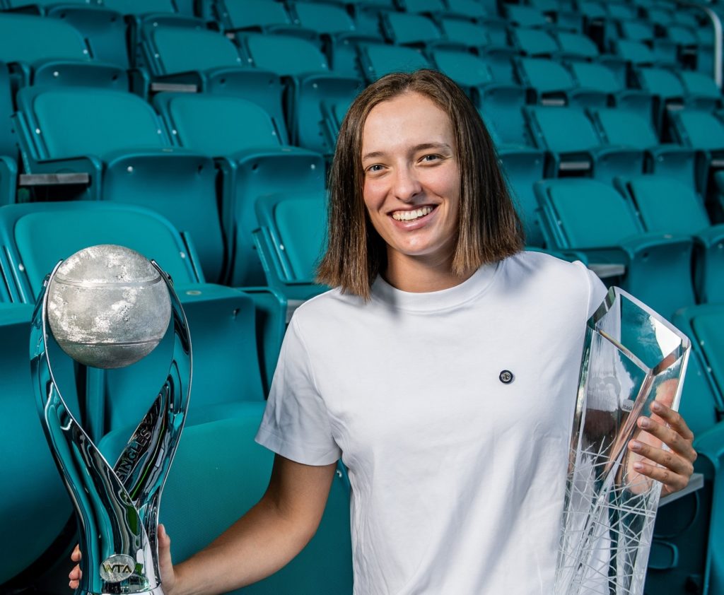 Iga Swiatek holds the Miami trophy and the world number one trophy.