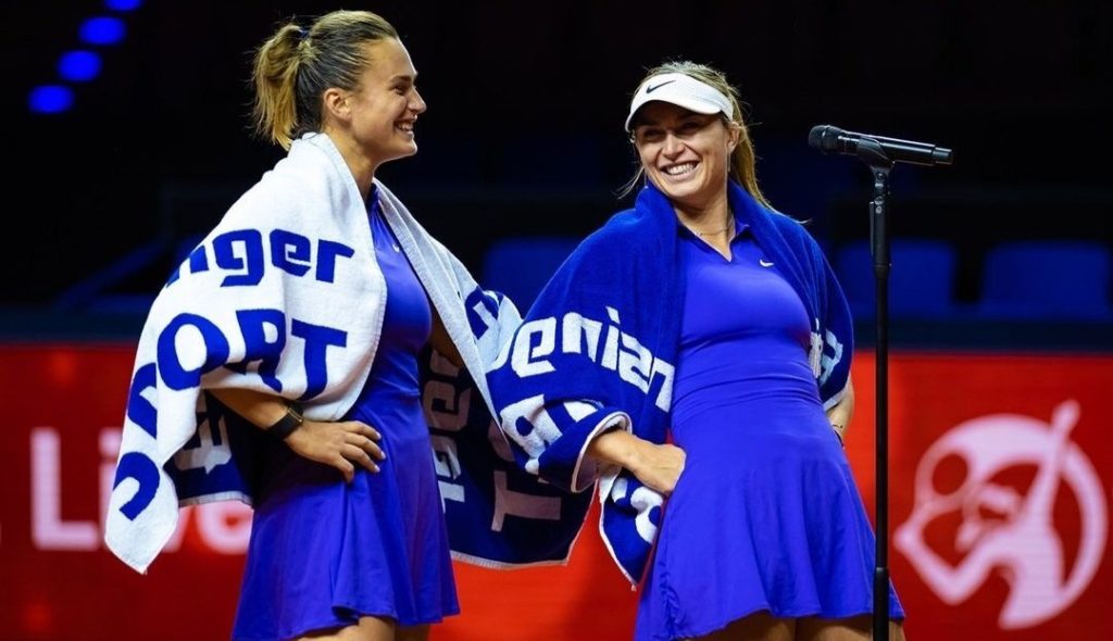 Aryna Sabalenka and Paula Badosa stand on court smiling.