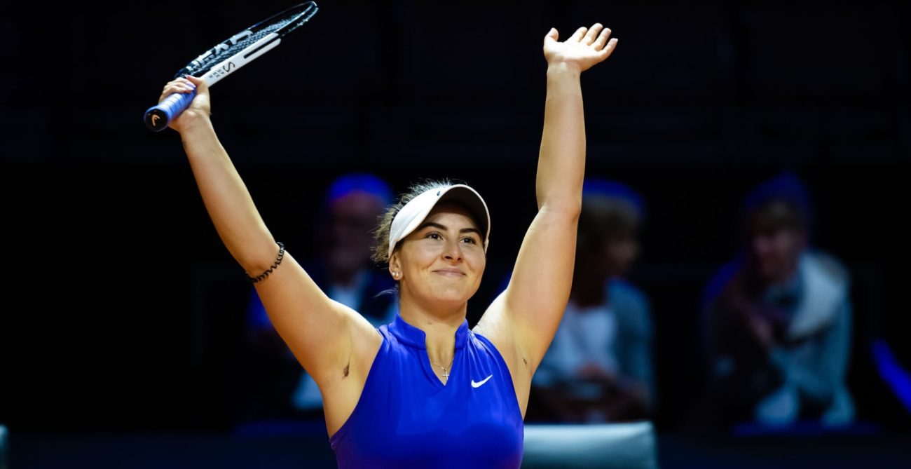 Bianca Andreescu raises her arms over head head in celebration.