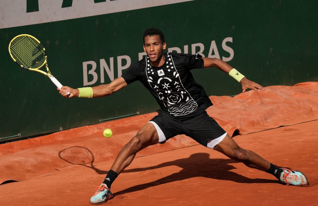 Felix Auger-Aliassime slides into a forehand.