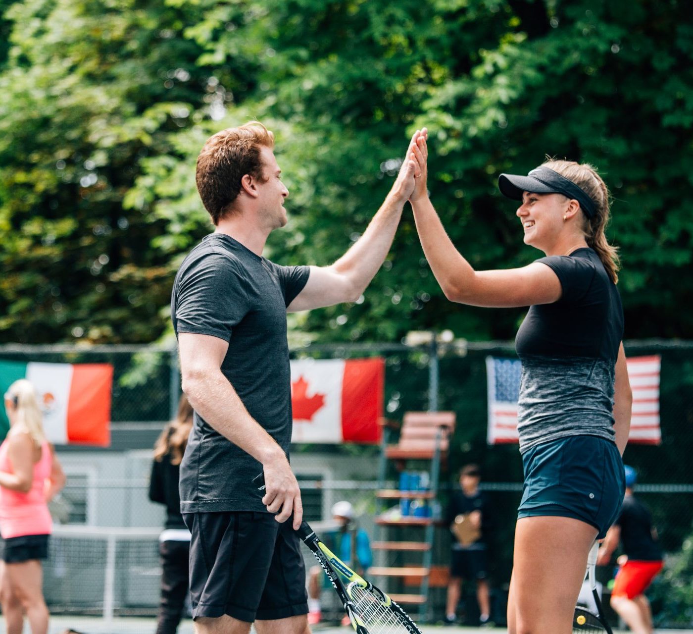 Smiling tennis players high five each other