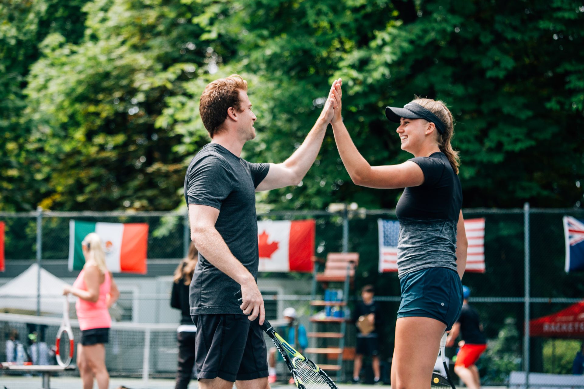 Smiling tennis players high five each other