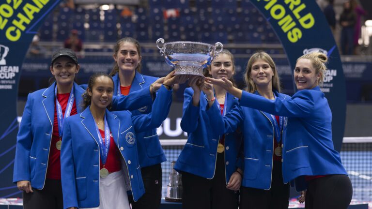 From left to right: Heidi El Tabakh, Leylah Fernandez, Rebecca Marino, Marina Stakusic, Eugenie Bouchard, and Gabriela Dabrowski hold up the Billie Jean King Cup trophy while wearing their blue blazers.