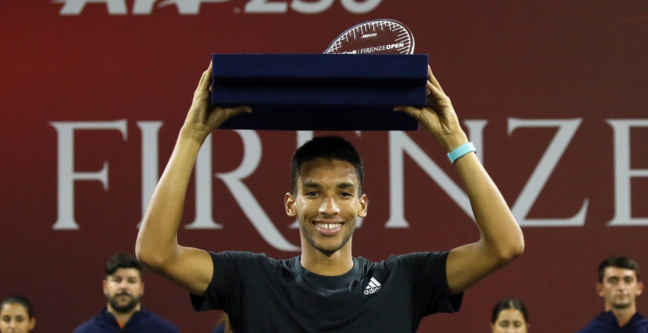 Felix Auger-Aliassime holds the Florence trophy above his head.