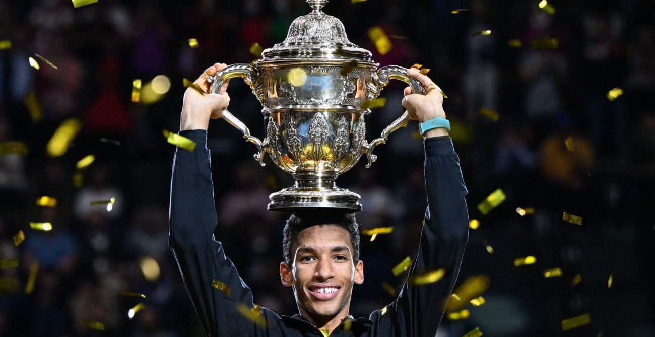 Felix Auger-Aliassime holds the Basel trophy above his head.