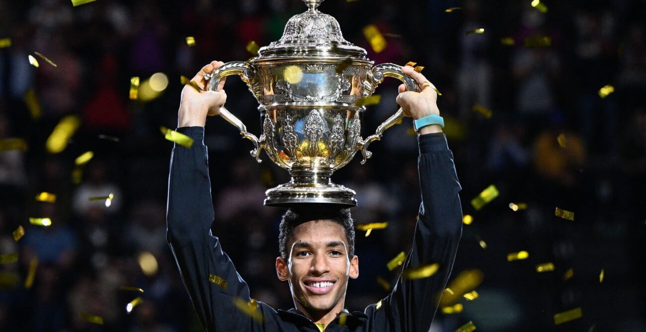 Felix Auger-Aliassime holds the Basel trophy above his head.
