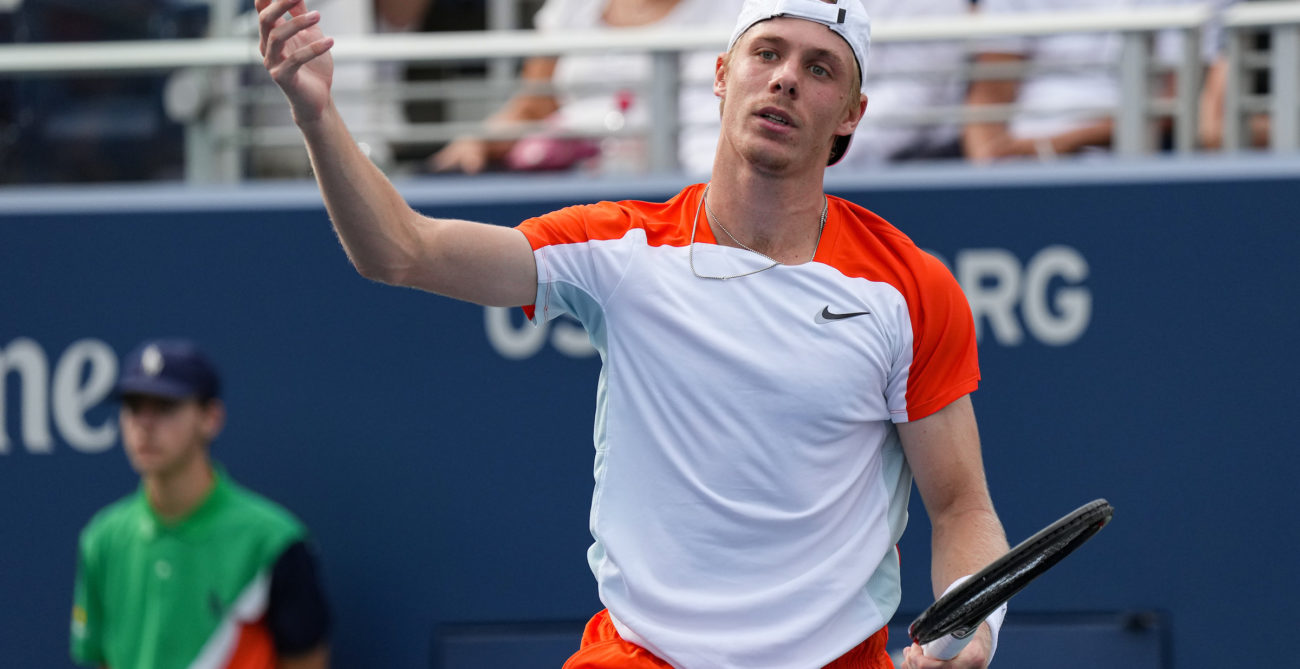Denis Shapovalov raises a hand in the air to express frustration.