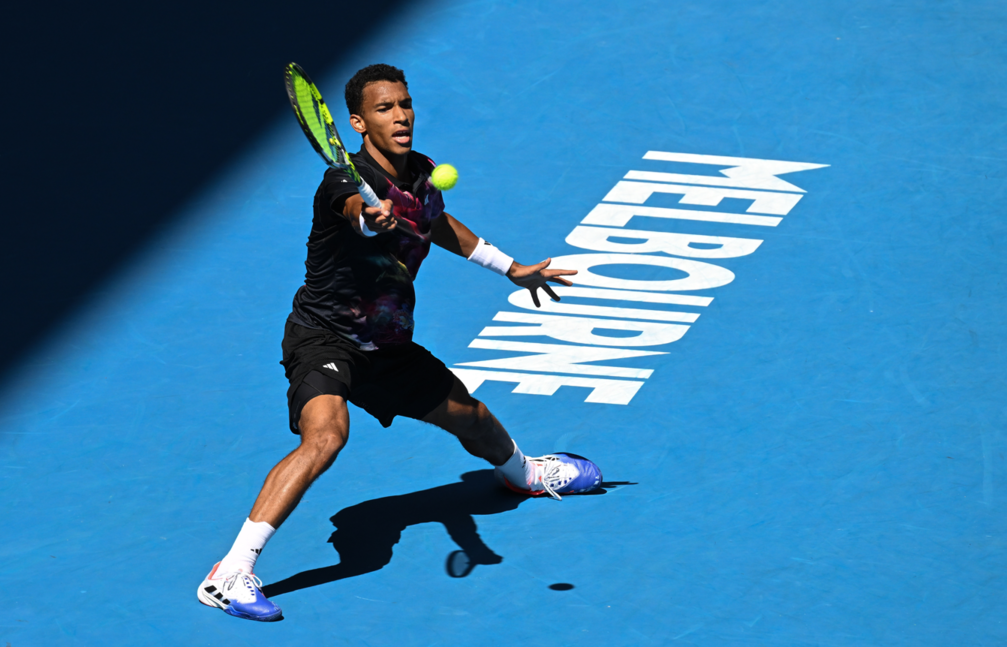 Felix Auger-Aliassime slides to hit a forehand.