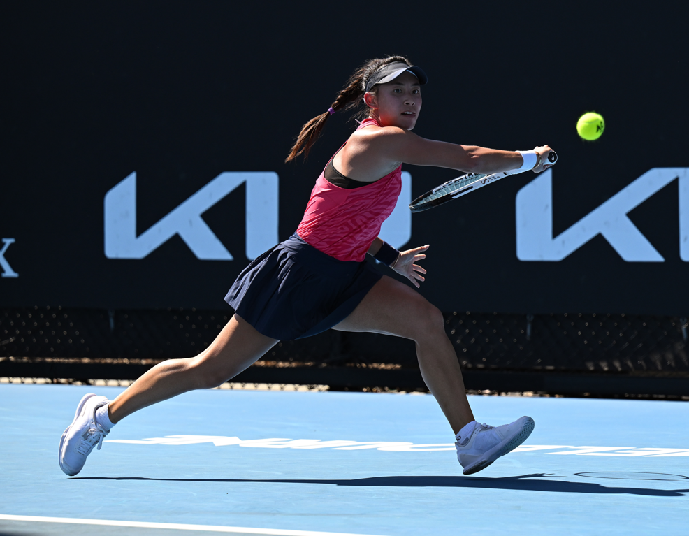 Carol Zhao lunges to hit a backhand.