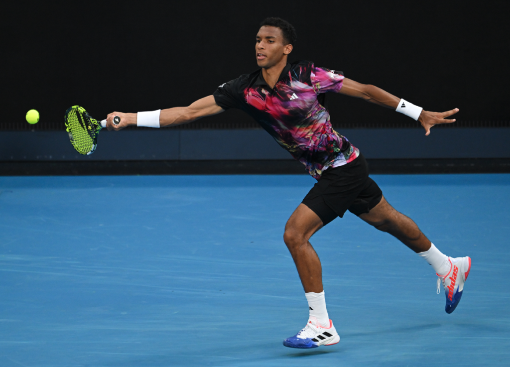 Felix Auger-Aliassime reaches out to hit a forehand.