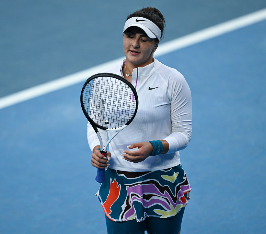 Bianca Andreescu looks down at her racket strings.