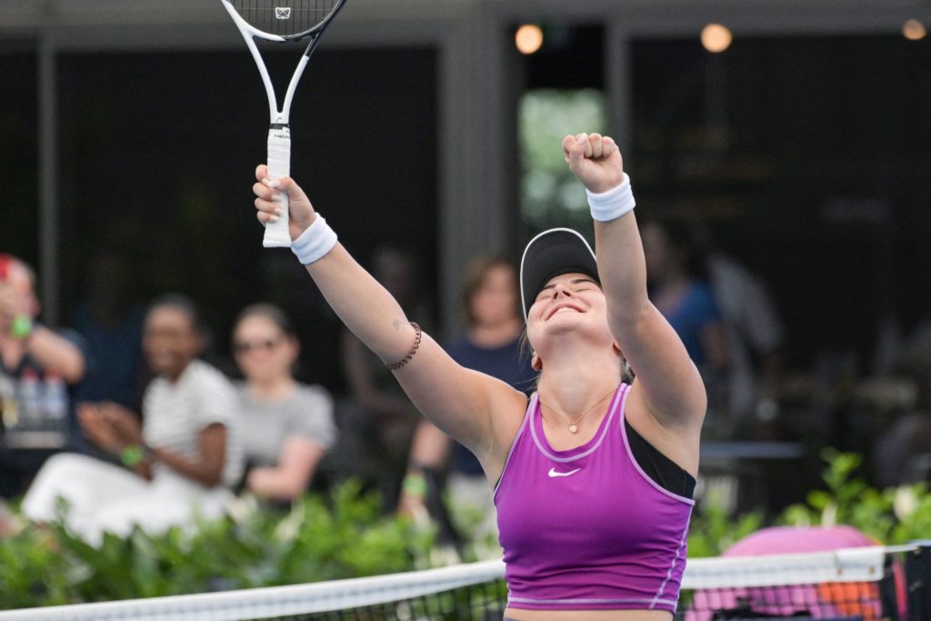 Bianca Andreescu raises her hands over her head in triumph.