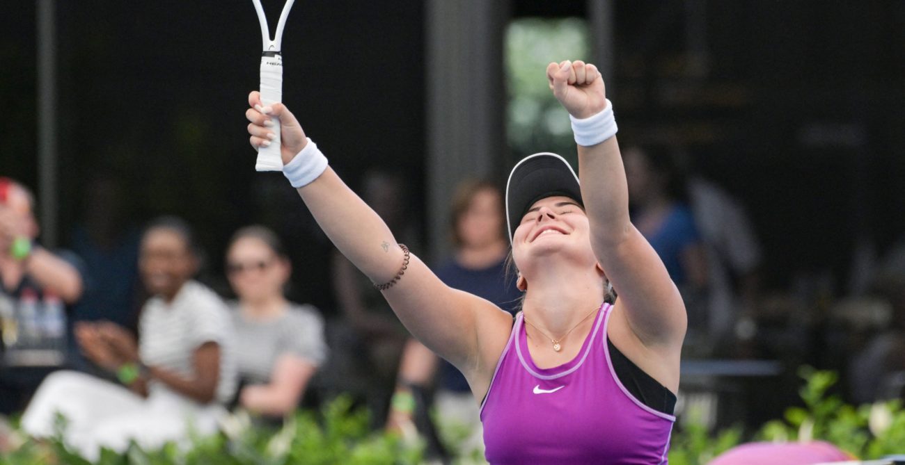 Bianca Andreescu raises her hands over her head in triumph.