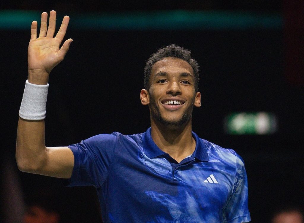 Felix Auger-Aliassime waves and smiles.