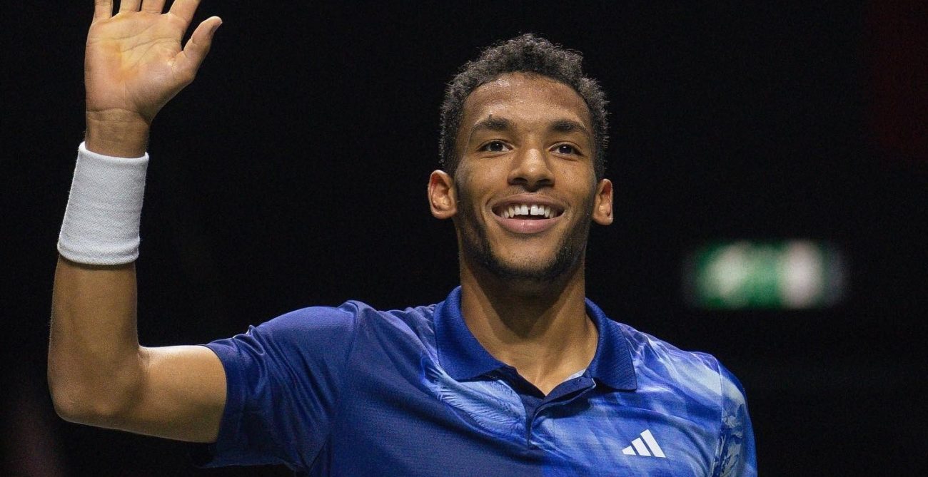 Felix Auger-Aliassime waves and smiles.