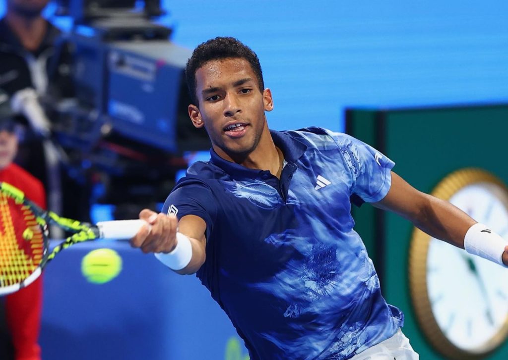 Felix Auger-Aliassime lunges to hit a forehand.