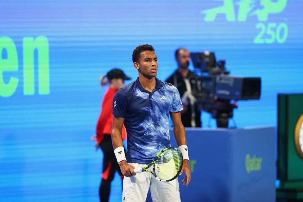 Felix Auger-Aliassime stands and looks across the court.