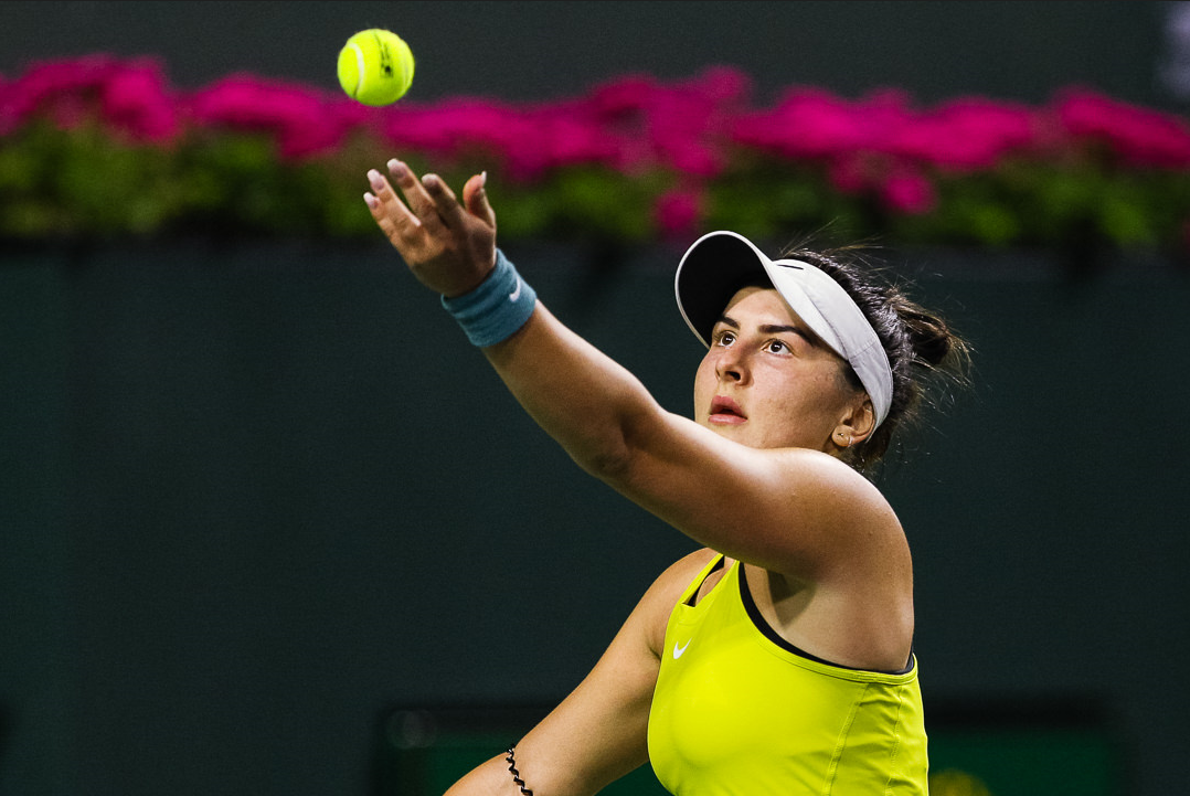 Bianca Andreescu tosses up a ball to serve.