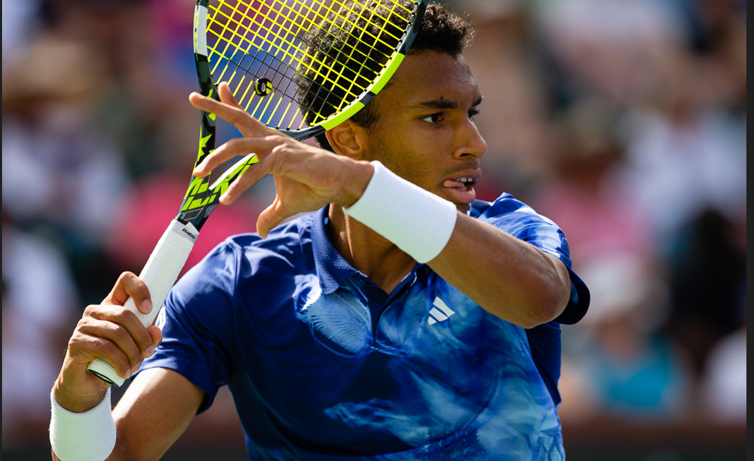 Felix Auger-Aliassime winds up to hit a forehand.