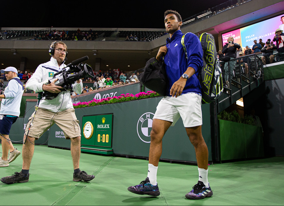 Felix Auger-Aliassime walks onto the court.